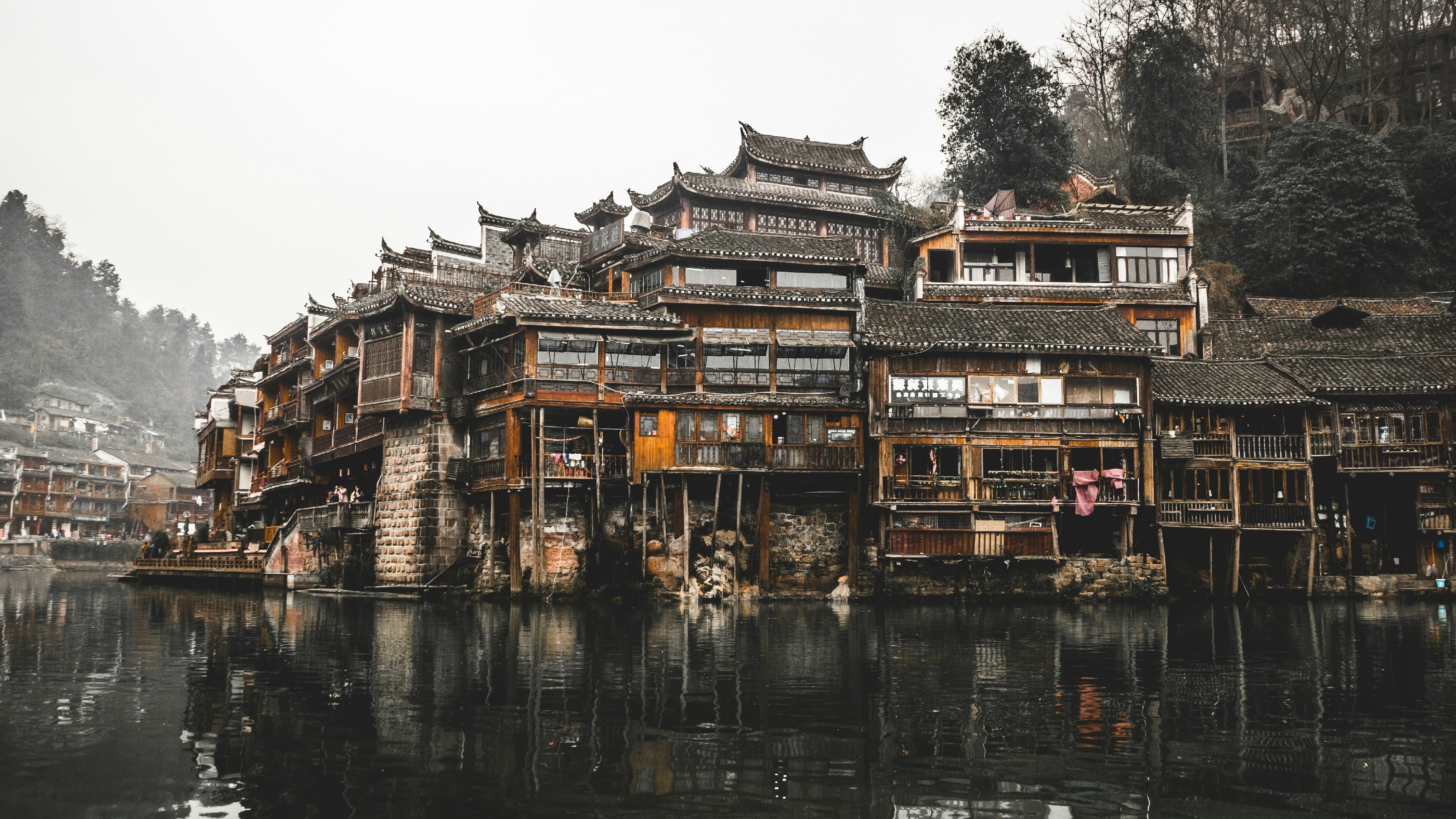 Fenghuang ancient town at dusk — stilt houses along the Tuojiang River